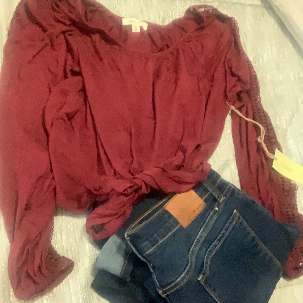 Burgundy blouse with lace on side trim. Stretchy material and ties at waist.